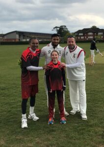 Four cricketers modelling Guildford City Youth Project coloured and white kits including a young girl